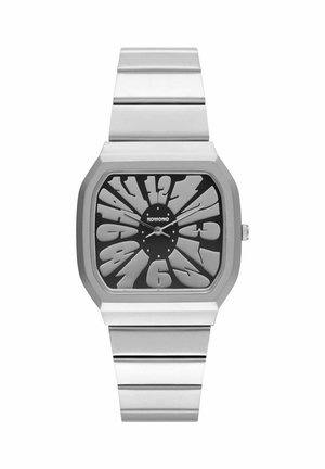 Montre en acier inoxydable argenté avec un cadran noir audacieux, des chiffres surdimensionnés et un design rectangulaire épuré. Mouvement à quartz avec un bracelet minimaliste.