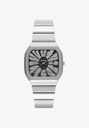 Montre en acier inoxydable argenté avec un cadran noir audacieux, des chiffres surdimensionnés et un design rectangulaire épuré. Mouvement à quartz avec un bracelet minimaliste.