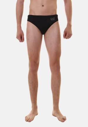 Slip da nuoto neri realizzati in tessuto morbido, con un design a vita bassa e un piccolo logo EA7 argento sul lato sinistro.