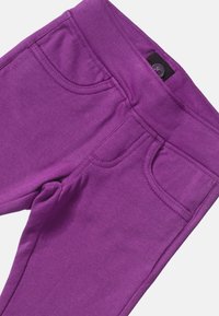 Fioletowe legginsy z bawełny z domieszką, z elastycznym pasem, przednimi kieszeniami i gładkim wykończeniem. Posiadają tonalne szwy dla dodania szczegółów.