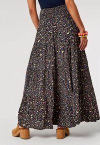 Maxi nederdel med elastisk talje i marineblåt stof med et blomsterprint i gult og pink. Udfoldet design med en lagdelt struktur.
