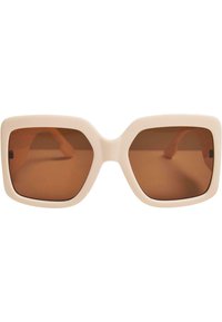 Ochelari de soare supradimensionați cu o ramă din plastic bej cremos și lentile tonificate în nuanțe de brown. Design unghiular, care subliniază formele geometrice îndrăznețe.