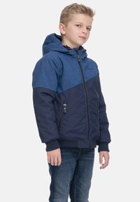 Giacca a cappuccio bicolore blu e navy con chiusura a zip, tasche laterali e polsini a coste. Il tessuto ha una finitura testurizzata.