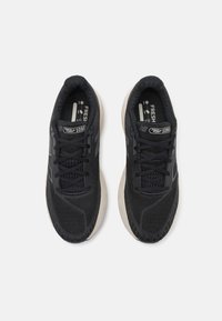 Chaussures de sport noires avec tige en mesh, bout rond, lacets et semelle extérieure en caoutchouc. Présente les étiquettes "Fresh Foam" et le modèle "1080".
