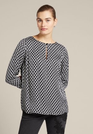 Zwart-witte blouse met een patroon, ronde halslijn, sleutelgatdetail en lange mouwen. Gemaakt van een gladde stof met een subtiele glans.