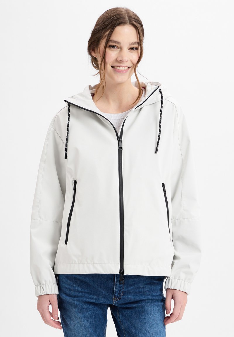 Helle graue Jacke mit Reißverschluss und Kapuze, schwarzen Akzenten, elastischen Bündchen und zwei Fronttaschen, hergestellt aus einem glatten, wasserabweisenden Material.