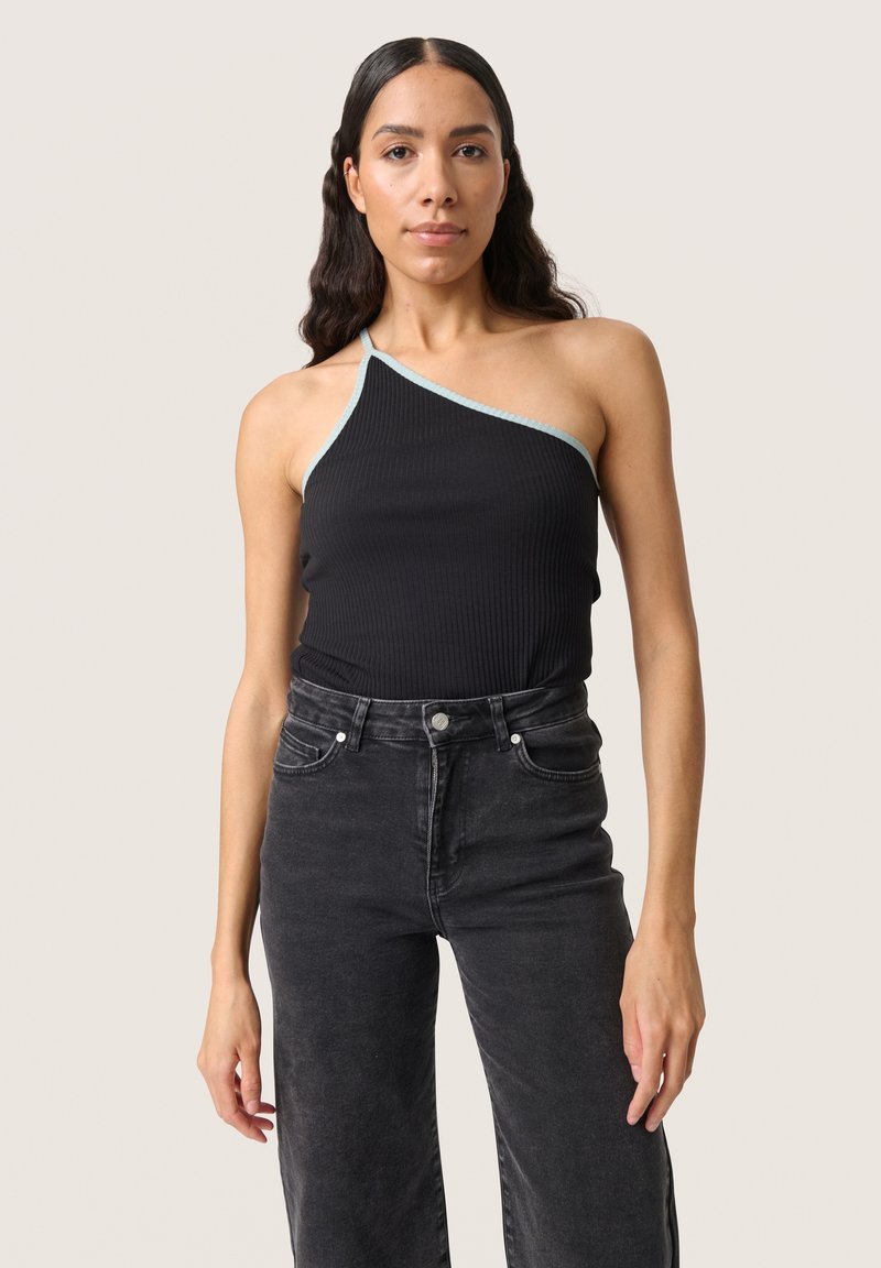 Black ribbed tank top with one shoulder strap and light blue trim, paired with high-waisted black jeans, showcasing a fitted silhouette.