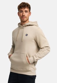 Beige katoenen hoodie met trekkoorden, voorzak en klein marineblauw logo op de borst. Heeft geribbelde manchetten en zoom, gladde textuur.