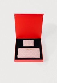 Set di portafoglio in pelle rosa firmato Valentino, presentato in una scatola rossa, composto da un portafoglio con zip e un porta carte con logo in rilievo e motivi geometrici.