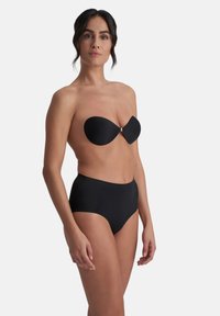 Top bikini nero senza spalline con una texture liscia e una chiusura in argento, abbinato a slip bikini neri a vita alta, design minimale.