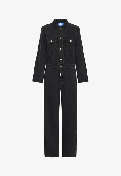 Melna denima kombinezons ar garām piedurknēm, pogājamu priekšpusi, divām krūšu kabatām un pieguļošu jostasvietu. Gluda tekstūra un sašaurinātas kājas.