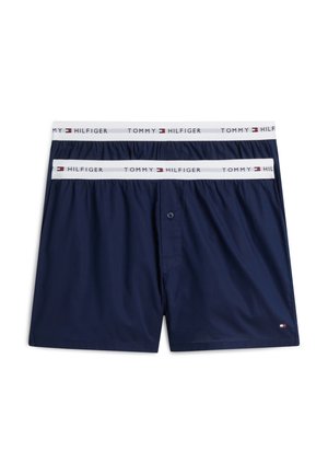 Twee paar marineblauwe Tommy Hilfiger boxershorts met witte elastische taillebanden met de merknaam en het logo.