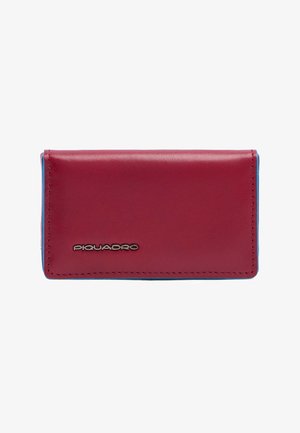 Cartera rectangular de cuero burdeos con costuras visibles y un pequeño logo plateado "Piquadro" en el frente, bordes azules ligeramente visibles.
