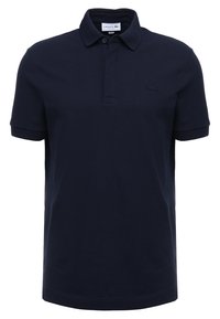 Navy blue polo shirt made of cotton, featuring a classic collar, three-button placket, and embroidered logo on the chest. Short sleeves.