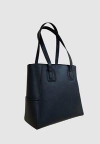 Borsa tote in pelle nera con design strutturato, base piatta, due manici robusti e accenti squadrati sul fronte. Texture liscia, stile minimalista.