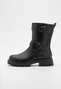 Bottine noire avec un extérieur en cuir brillant et des accents en imprimé serpent texturé. Comprend deux larges sangles avec des boucles circulaires et une semelle épaisse.