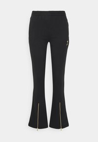 Čierne rozšírené teplákové nohavice s detailom zlatého zipsu na spodnom okraji, vyrobené z jemného materiálu, s elastickým pásom a diskrétnym brandingom.