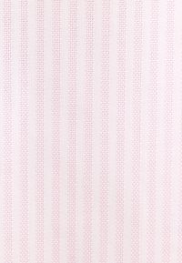 Tissu rose clair avec des rayures texturées verticales créant un motif discret en relief sur toute la surface.