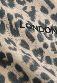 Leparda raksta audums krēmkrāsā un melnā, ar vārdu "LONDON" treknās melnās burtnēs. Mīksta tekstūra ar smalku spīdumu.