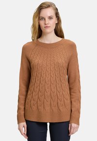 Brauner Kabelstrickpullover mit Rundhalsausschnitt und geripptem Saum. Enganliegende lange Ärmel, strukturiertes Muster und weiches Material.