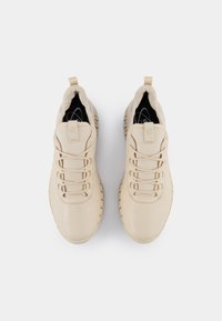 Scarpe sportive beige con tomaia in leather texture, punta tonda e sei occhielli per i lacci. Suola in gomma rigata per una migliore aderenza.