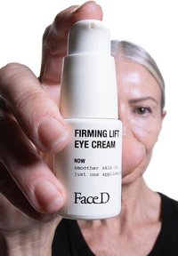 White cylindrical bottle of Firming Lift Eye Cream with black text, featuring a pump top and smooth matte finish.