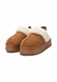 Scarpe slip-on in suede marrone con colletto bianco soffice, dotate di una suola in gomma spessa e una punta arrotondata.