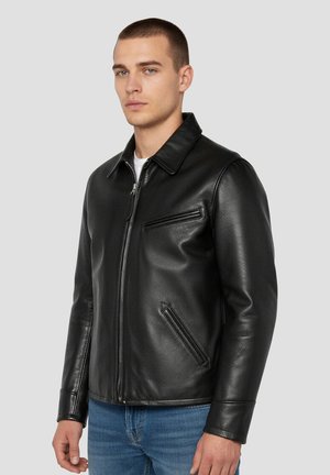 Chaqueta de cuero negro con cuello con solapa, dos bolsillos laterales y una textura lisa. Cierre frontal con cremallera, ajuste entallado.