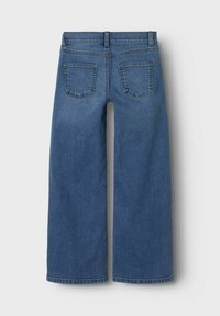 Dżinsy o szerokich nogawkach w ciemnoniebieskim denimu, z wysokim stanem, kieszeniami z tyłu oraz przeszyciami na szwach. Gładka tekstura.