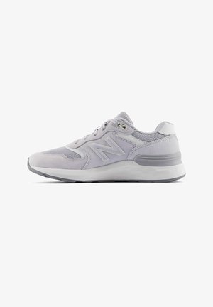 Baskets New Balance gris clair avec des panneaux en mesh et en daim, semelle intermédiaire blanche et semelle extérieure grise, vues de côté sur fond blanc.