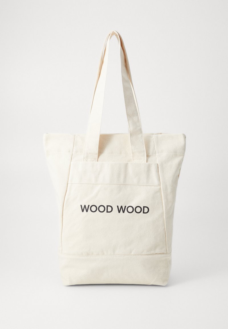 Saco tote em algodão creme com alças duplas. Apresenta um bolso frontal, detalhes cosidos e o texto "WOOD WOOD" em preto.