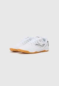 White athletic shoes with a textured surface, streamlined design, and a gum rubber sole, featuring black accents and breathable mesh.