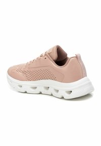 Zapatilla deportiva de color rosa claro con parte superior perforada, suela blanca acolchada y detalles texturizados en el talón y la lengua.