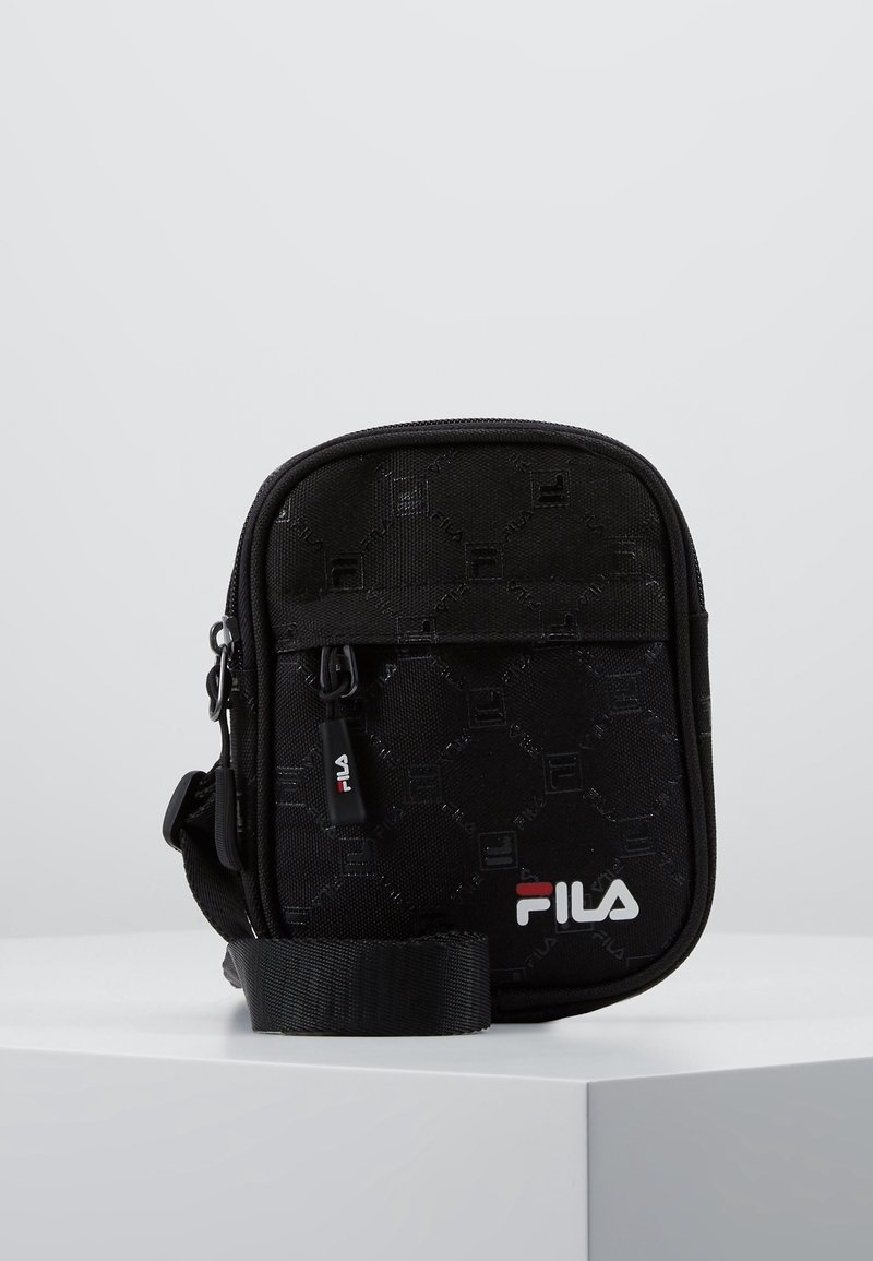 Czarna torba na ramię Fila z sześciokątnym wzorem, zamkiem błyskawicznym i regulowanym paskiem. Na dole znajduje się biało-czerwone logo.
