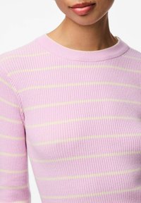 Ljusrosa ribbstickad tröja med korta ärmar, med horisontella gula ränder och rund halsringning. Mjuk textur och figurnära design.