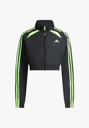 Chaqueta corta negra de Adidas con franjas verdes neón en las mangas y los hombros, cremallera frontal y logo de Adidas en el pecho.