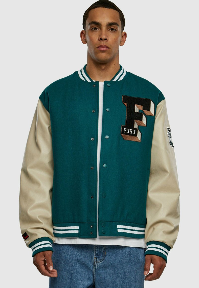 Jachetă de tip varsity în nuanțe de teal și crem, cu un logo brodat „F” și manșete cu dungi. Dispune de nasturi tip snap și o croială lejeră.