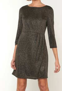 Kortärmad klänning i mörk metallisk tyg; har en rundad halsringning, figurnära överdel och avslappnad kjol med glittrande textur.