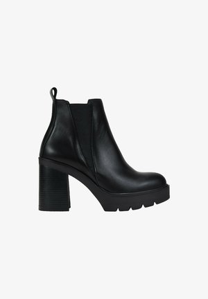 Botín negro de cuero con tacón alto grueso, paneles laterales elásticos, tirador y suela de goma con tacos.