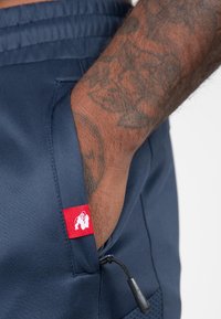 Marine sportshorts van ademende stof, met een rood label met gorillalogoo, verstelbaar trekkoord en een zijzak.