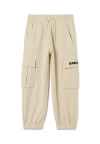 Pantalones deportivos beige con cintura elástica, cordón, dos bolsillos laterales y dos bolsillos tipo cargo, que presentan el texto "GAME" en negro.
