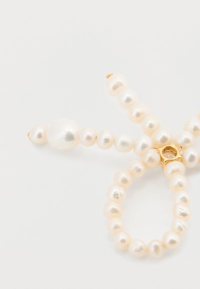 Joya de perlas que presenta perlas de agua dulce redondas y ovaladas de color crema claro, con un cierre dorado y superficie texturizada.