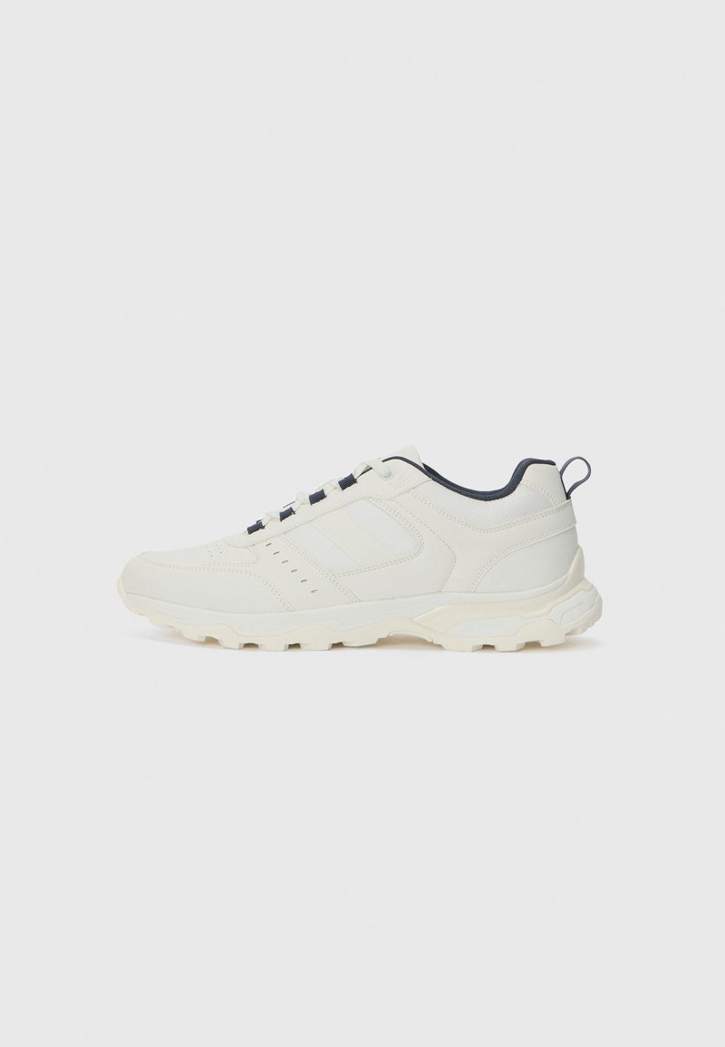 Lightweight athletic shoe in off-white with textured leather upper, navy accents, lace closure, and a sturdy rubber outsole.