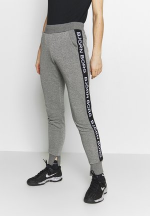 Grå sweatpants med en tapered passform, elastisk midjeband och sidostråk med texten "BJÖRN BORG" i svart. Slät textur.