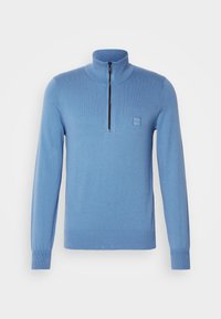 Pull-over bleu clair avec col à demi-fermeture éclair, poignets et ourlet côtelés, arborant une petite écusson logo sur la poitrine. Texture douce.