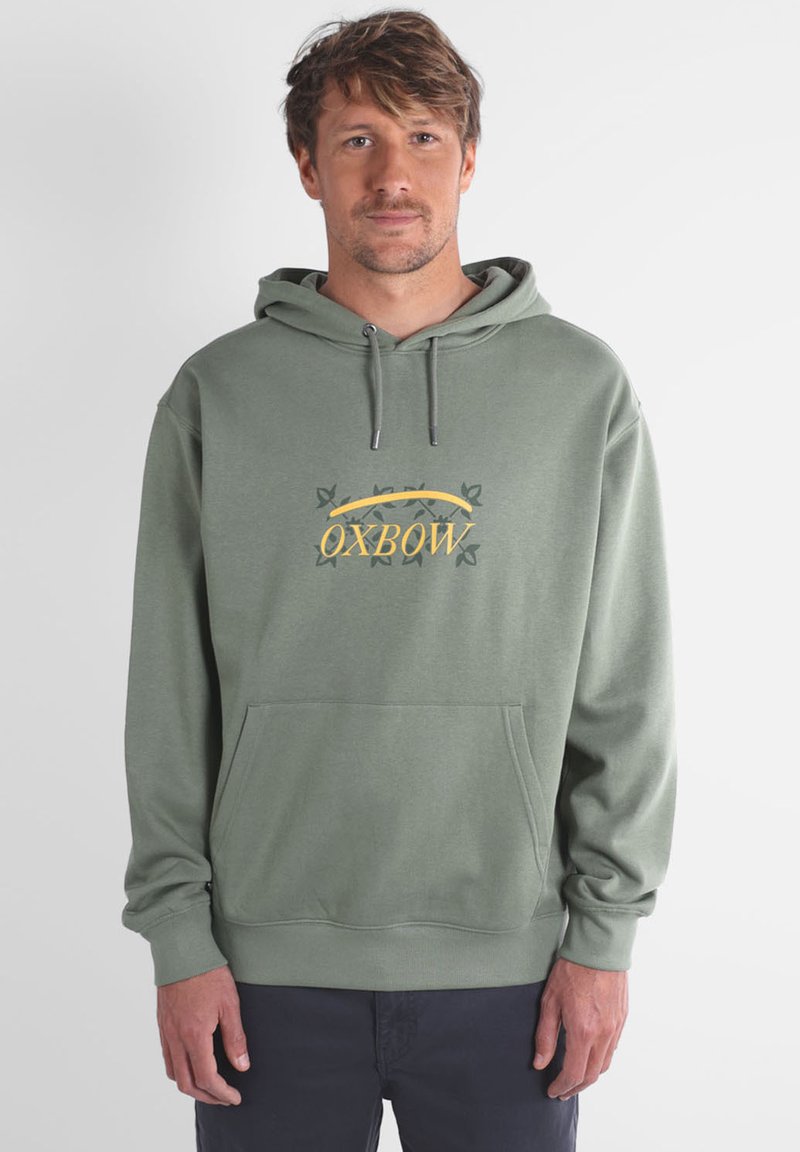Sweat à capuche vert avec une poche avant, un cordon de serrage à la capuche et un logo central affichant le mot "OXBOW" en jaune, accompagné d'accents décoratifs.
