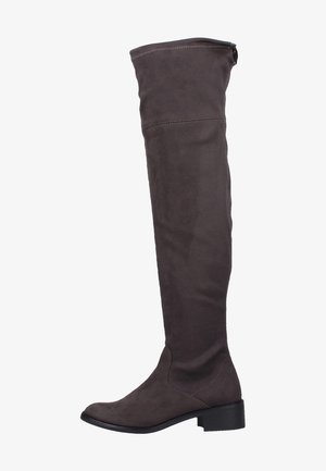 Bottes en daim marron au-dessus du genou avec une semelle plate, une texture douce et des détails de couture. Elles présentent une fermeture éclair discrète à l'arrière pour un enfilage facile.