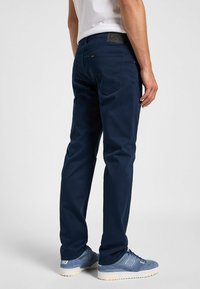 Pantaloni blu navy con design a gamba dritta, realizzati in morbido tessuto twill, dotati di tasche posteriori e di una toppa in pelle con marchio in vita.