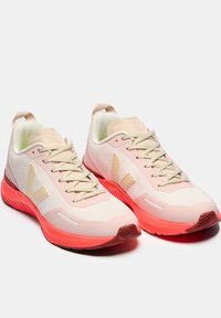 Light pink running shoes with a textured mesh upper, beige accents, and bright pink soles. Features a cushioned tongue and lace-up design.