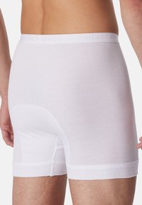 Vita ribbade boxerkalsonger med en mjuk elastisk midja. Funktioner inkluderar en slät yta och en nära passform.
